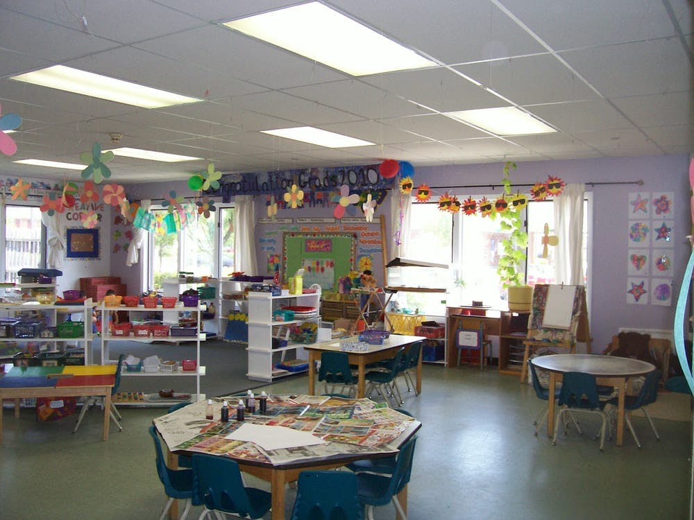 Classroom with tables, chairs, and shelves of learning materials