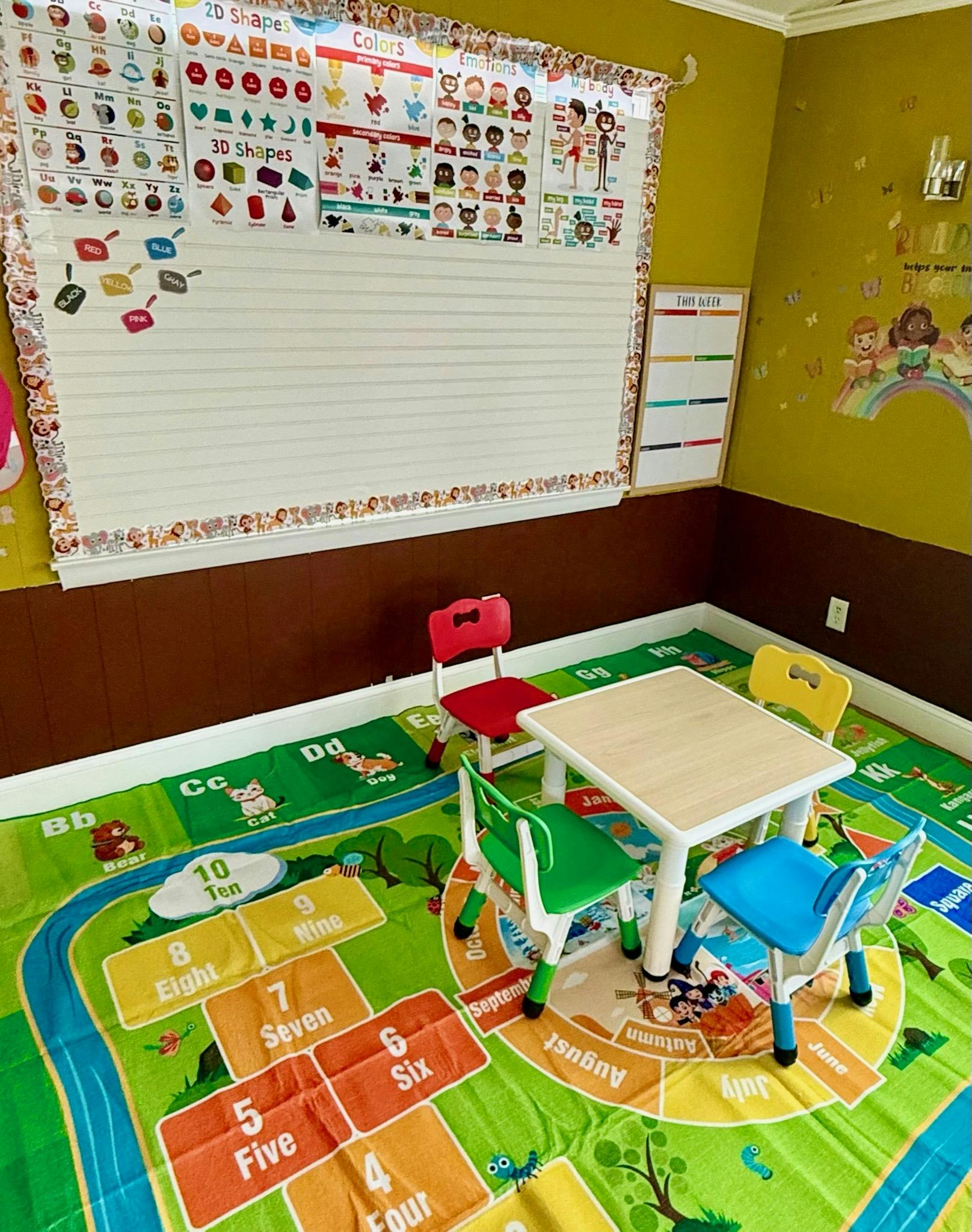 Classroom with children's table and chairs, alphabet and shape charts on wall