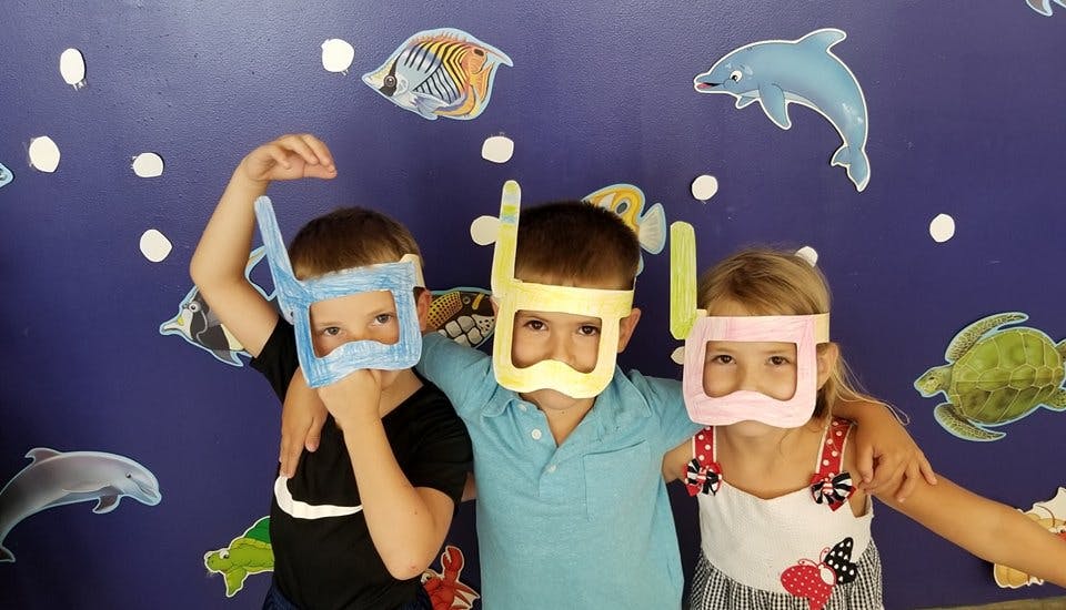 Three children wearing paper snorkel masks