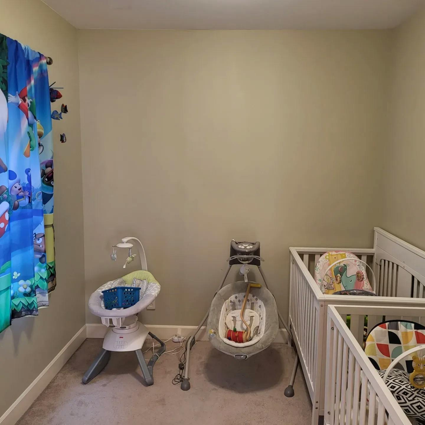 Two baby cribs and two baby swings in a room