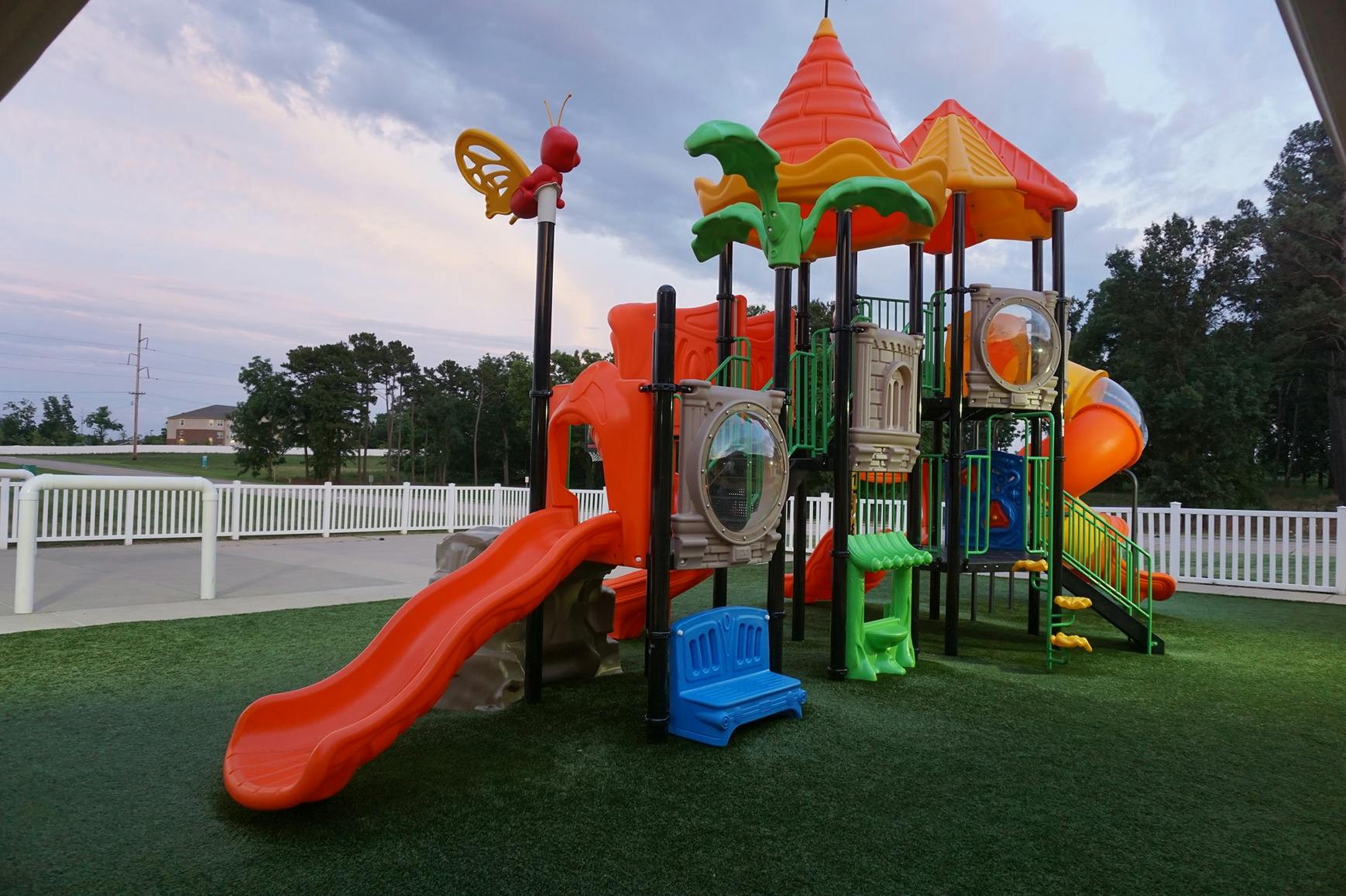 Playground with slides and climbing structures on artificial turf