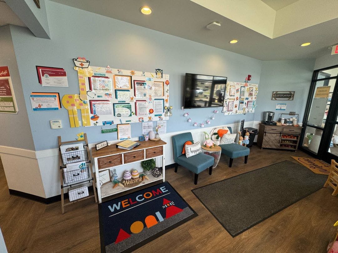 waiting area with blue chairs, coffee bar, and bulletin boards