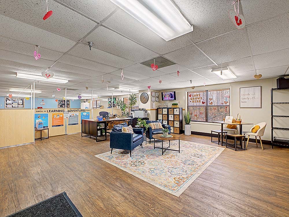 Lobby area with a sitting area, desks, and heart decorations on the ceiling