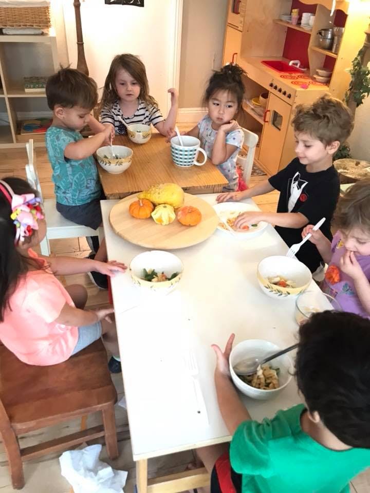 Children sitting around a table eating from an overhead view