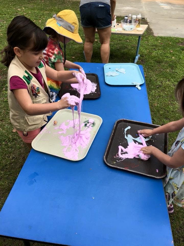 Children playing with pink slime on trays atable