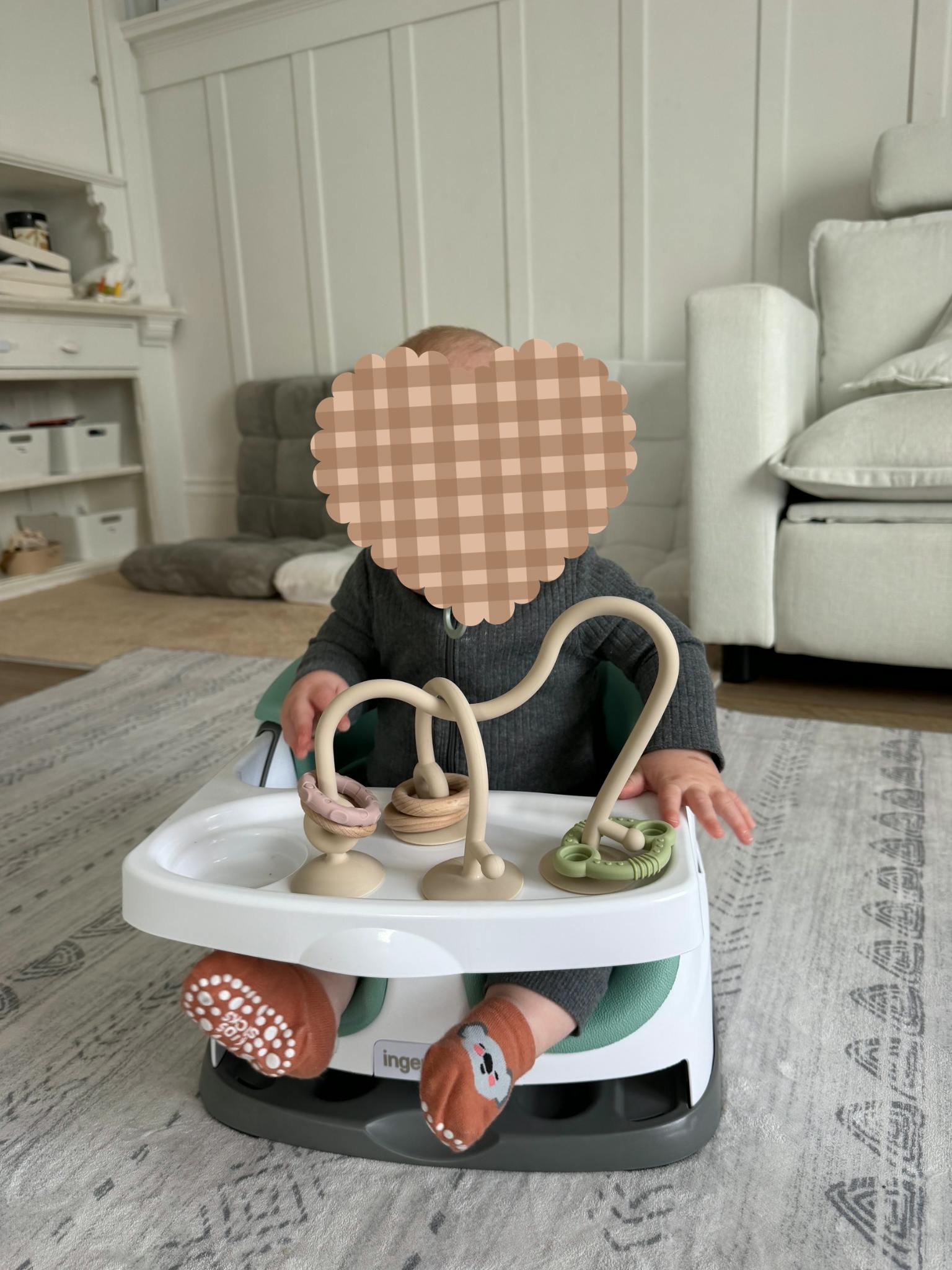 Child in a baby seat playing with attached toys