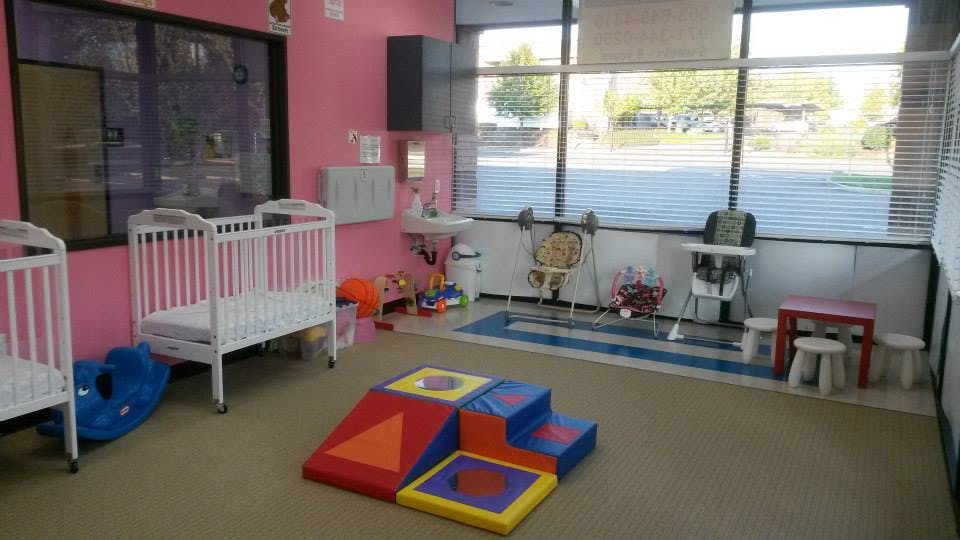 Nursery room with cribs, play mat, and high chairs
