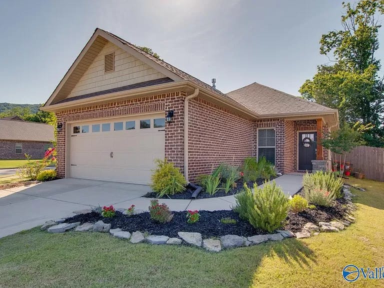 Brick house with an attached garage and landscaped front yard