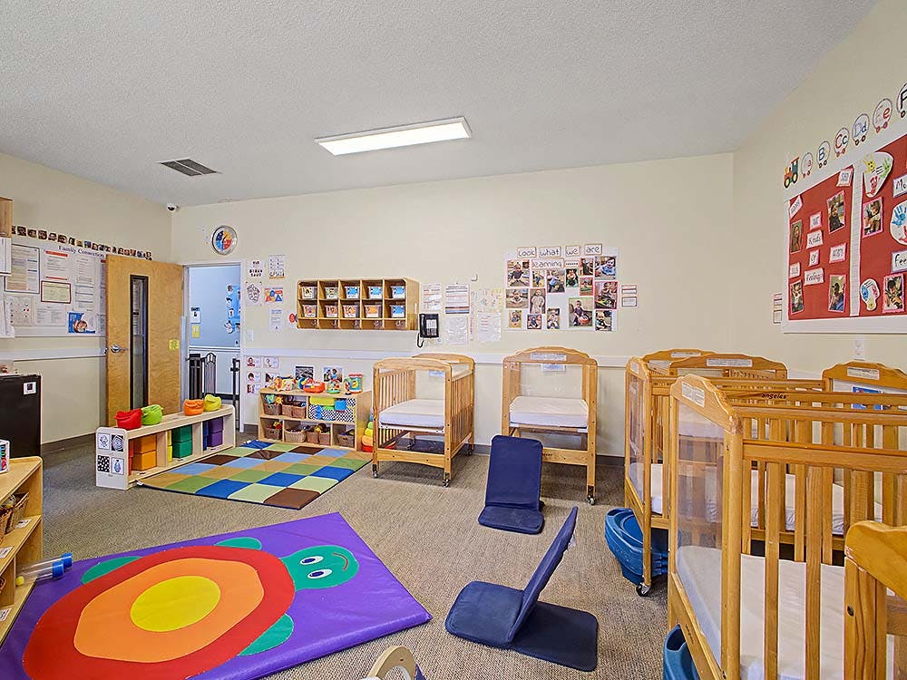 Cribs and play mats in a bright nursery room