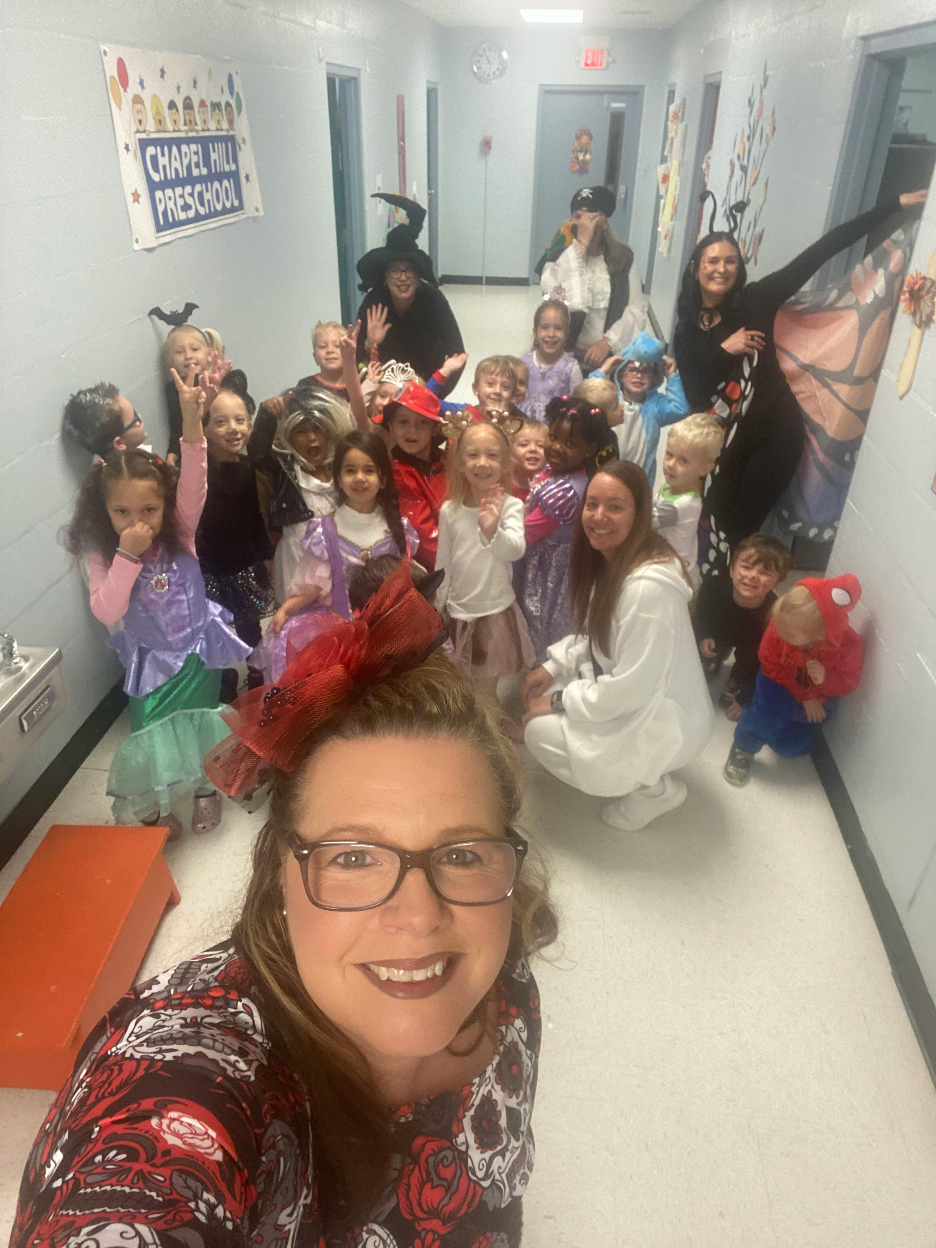Adult and children in costumes in a hallway