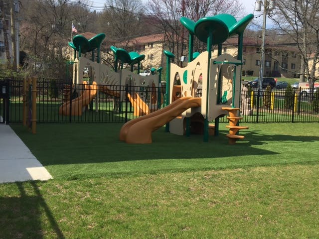 Playground with slides and climbing structures on green turf