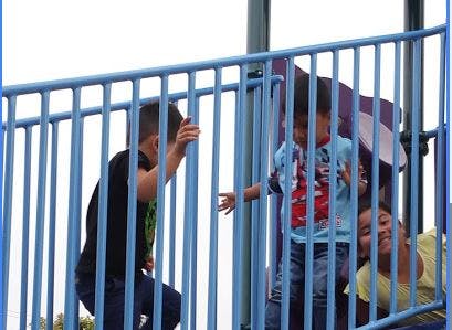 Three children playing on a playground structure