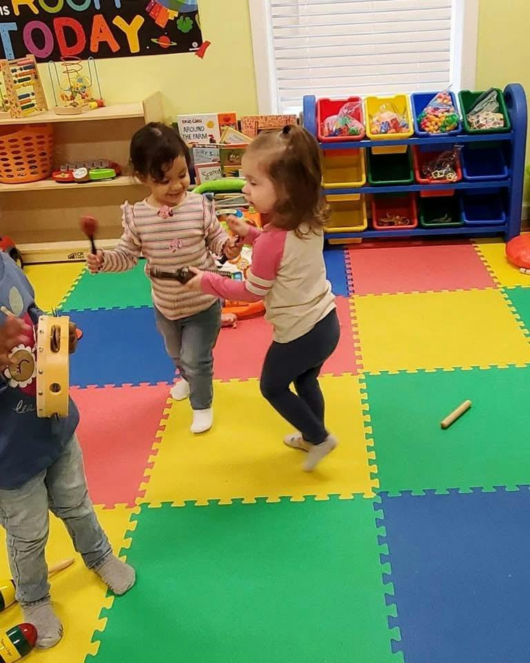 Children playing with musical instruments on a colorful foam floor