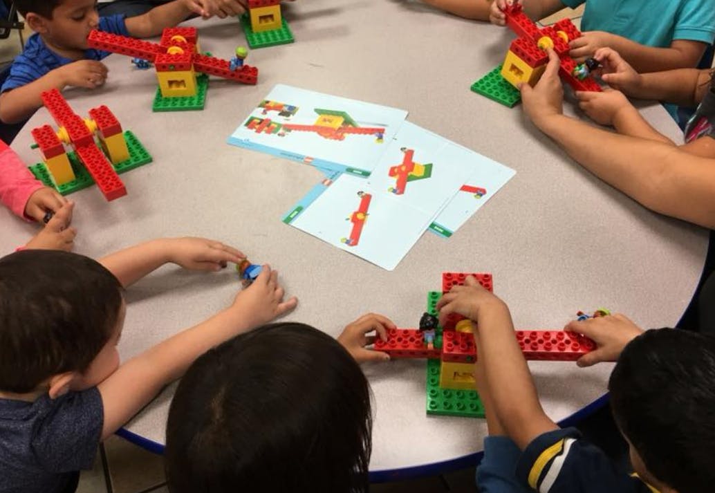 Children building with colorful interlocking blocks at a table