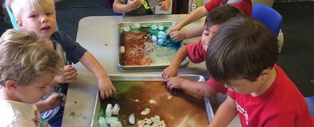 Children playing with sensory bins in a classroom