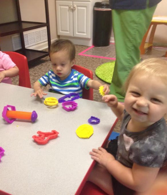 Two children playing with colorful toys at a table