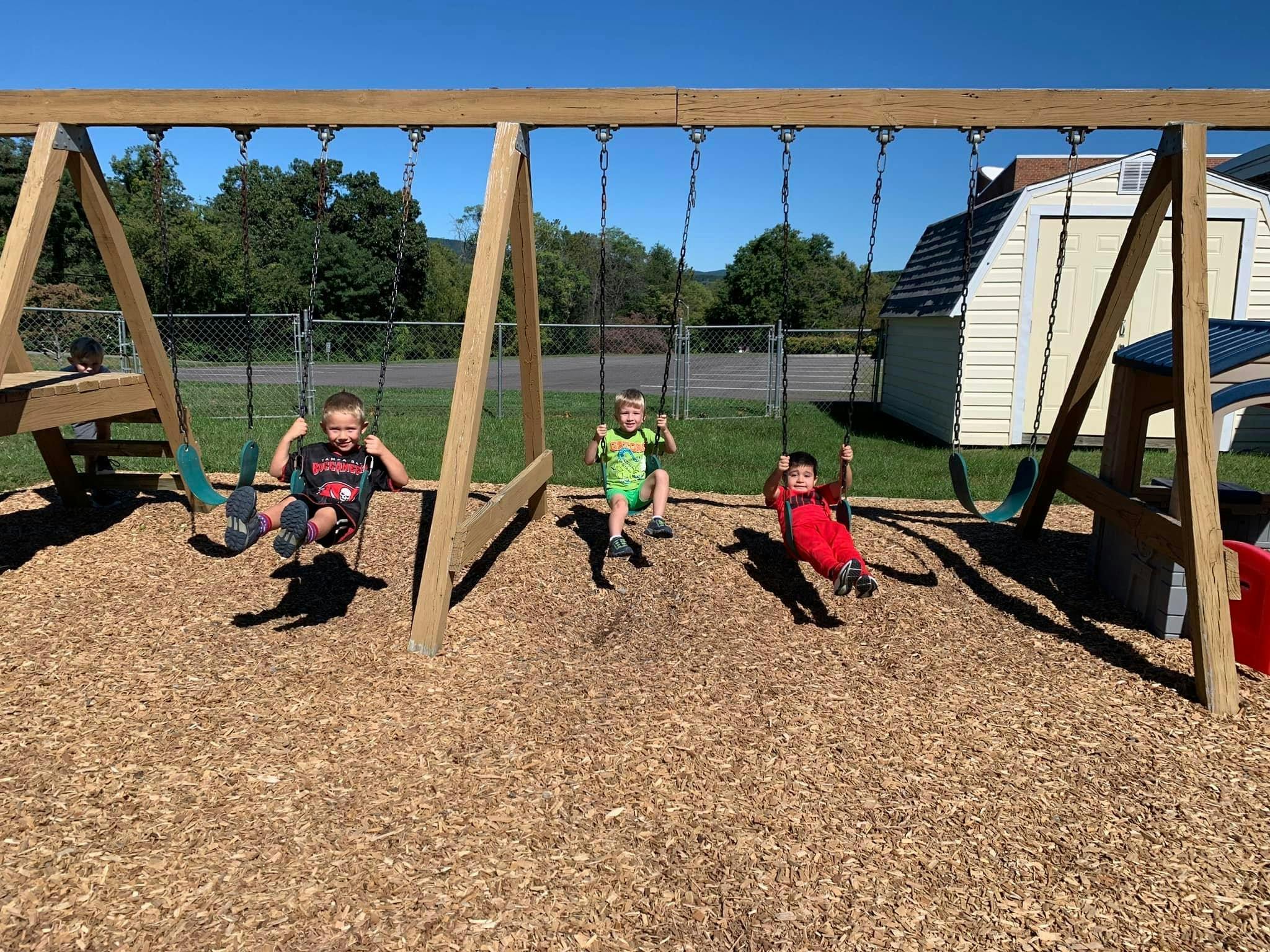 Three children on swings at a playground