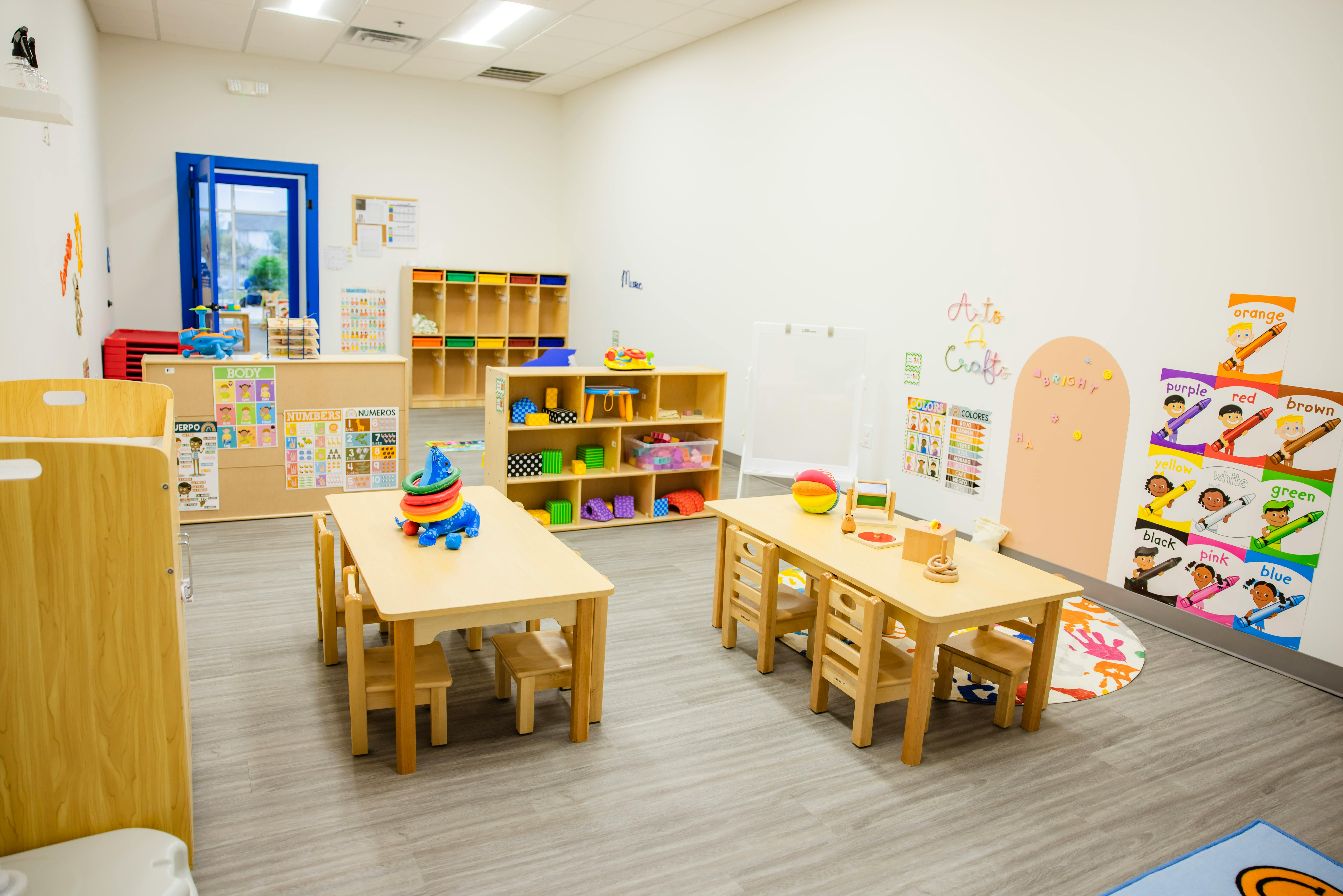 Empty classroom with small wooden tables and chairs