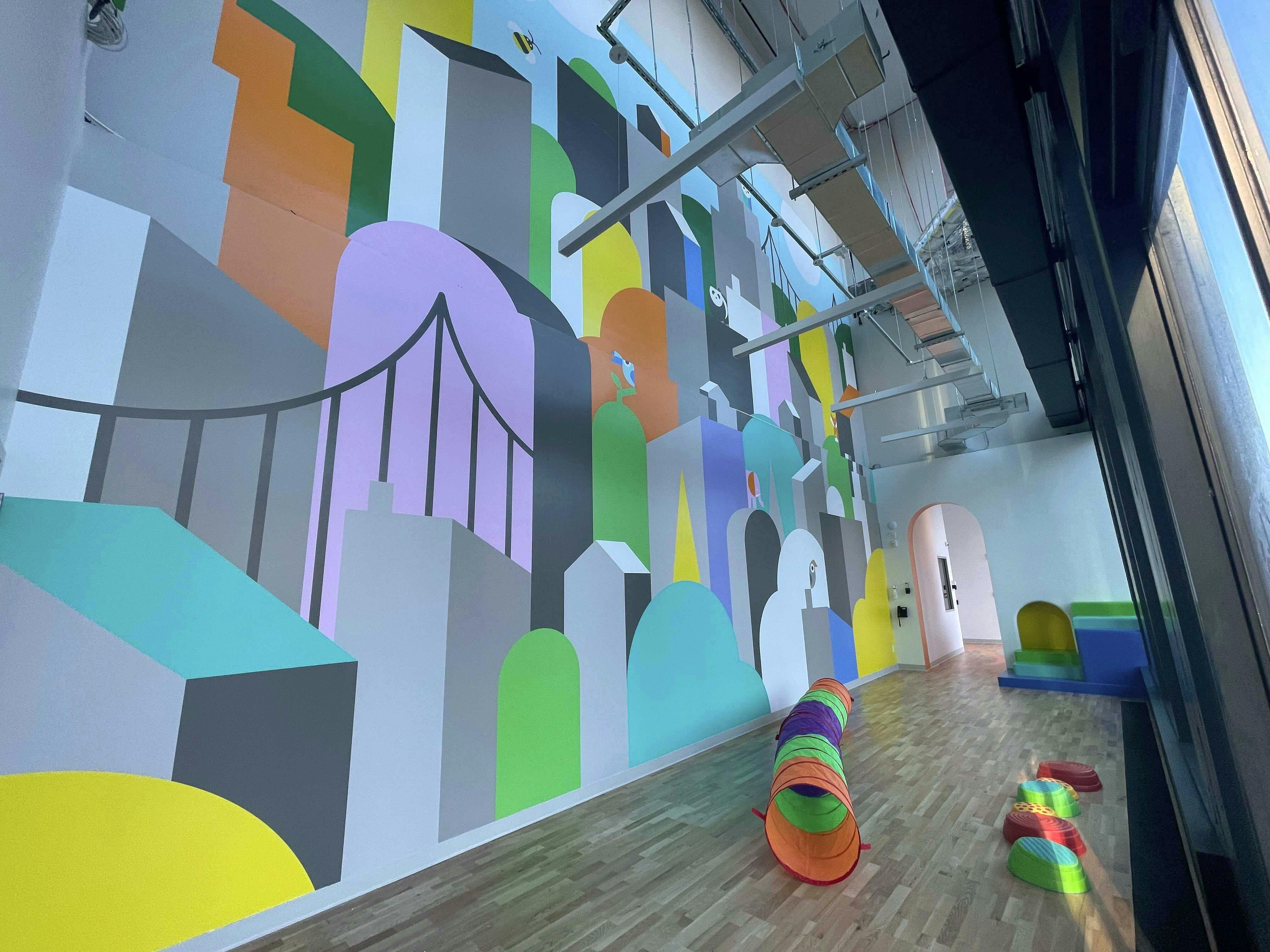 Playroom with colorful mural and soft play equipment