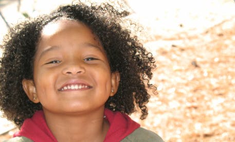 Child with curly hair smiling