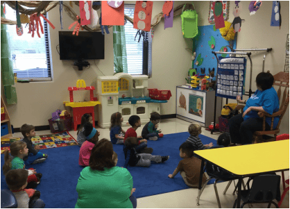 Adult reading to children in a classroom