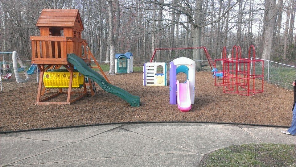 Playground with wooden playset, slides, swings, and climbing structures