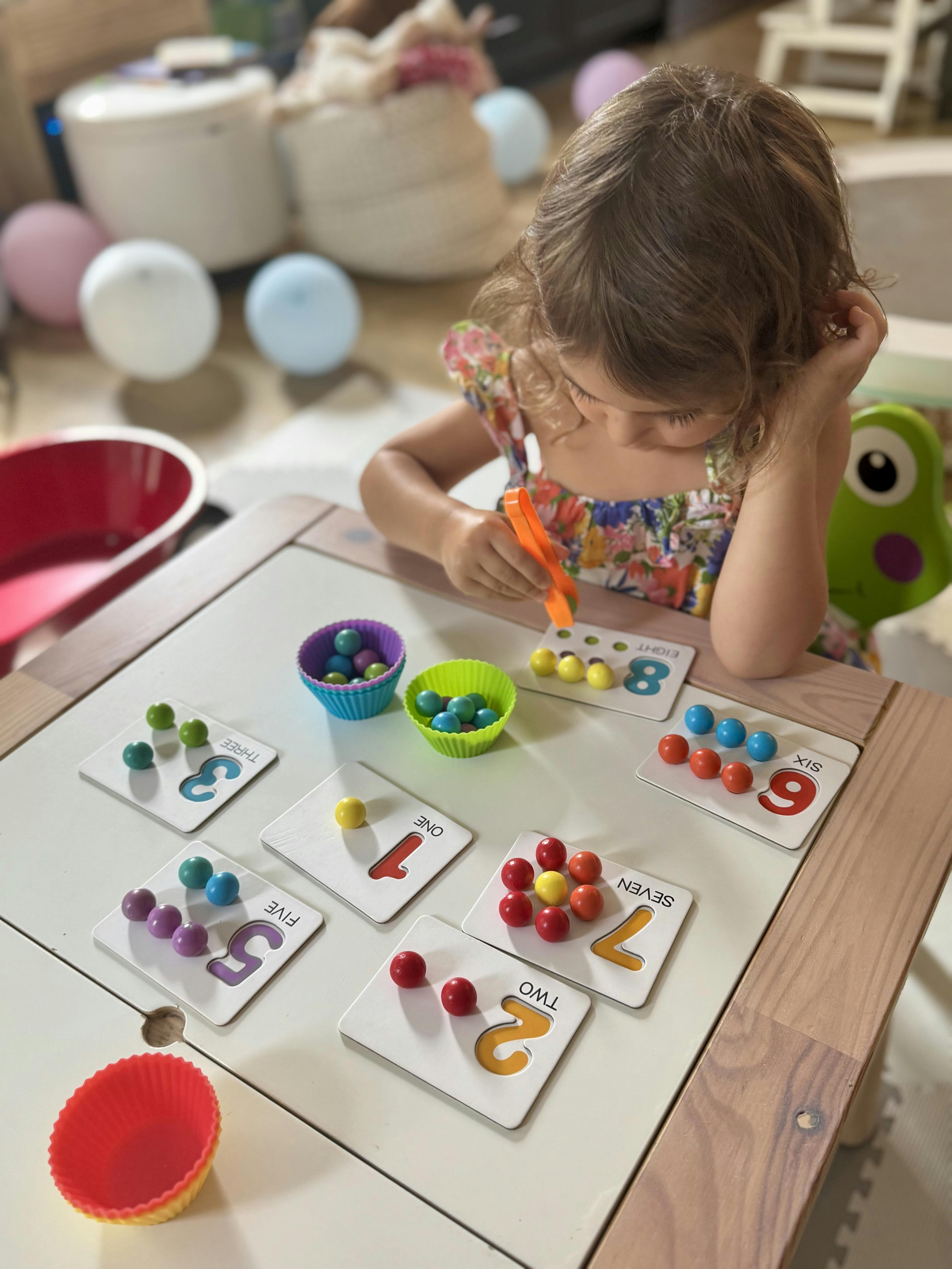 Child playing with number cards and colorful beads