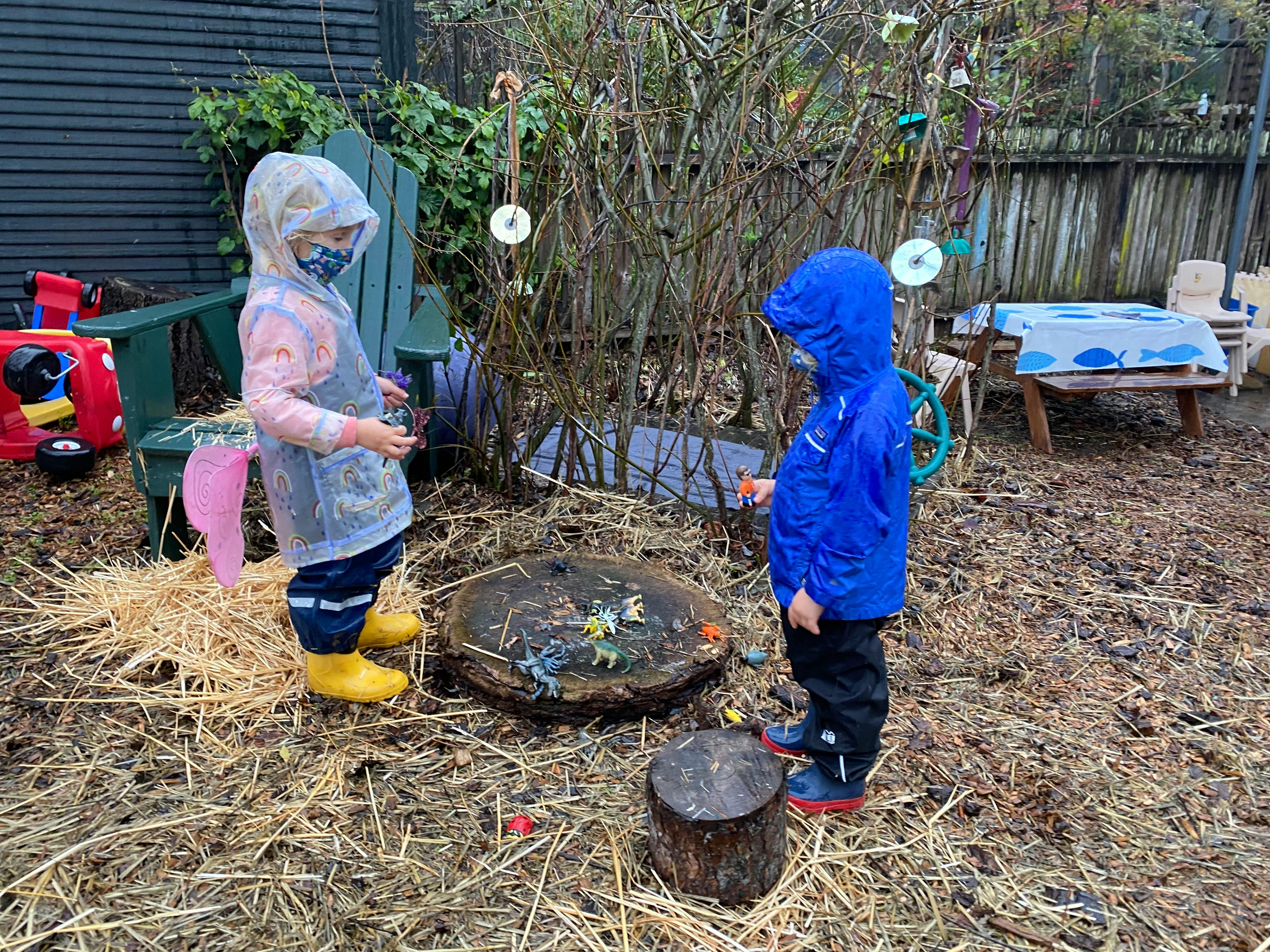 Two children in rain gear standing outdoors