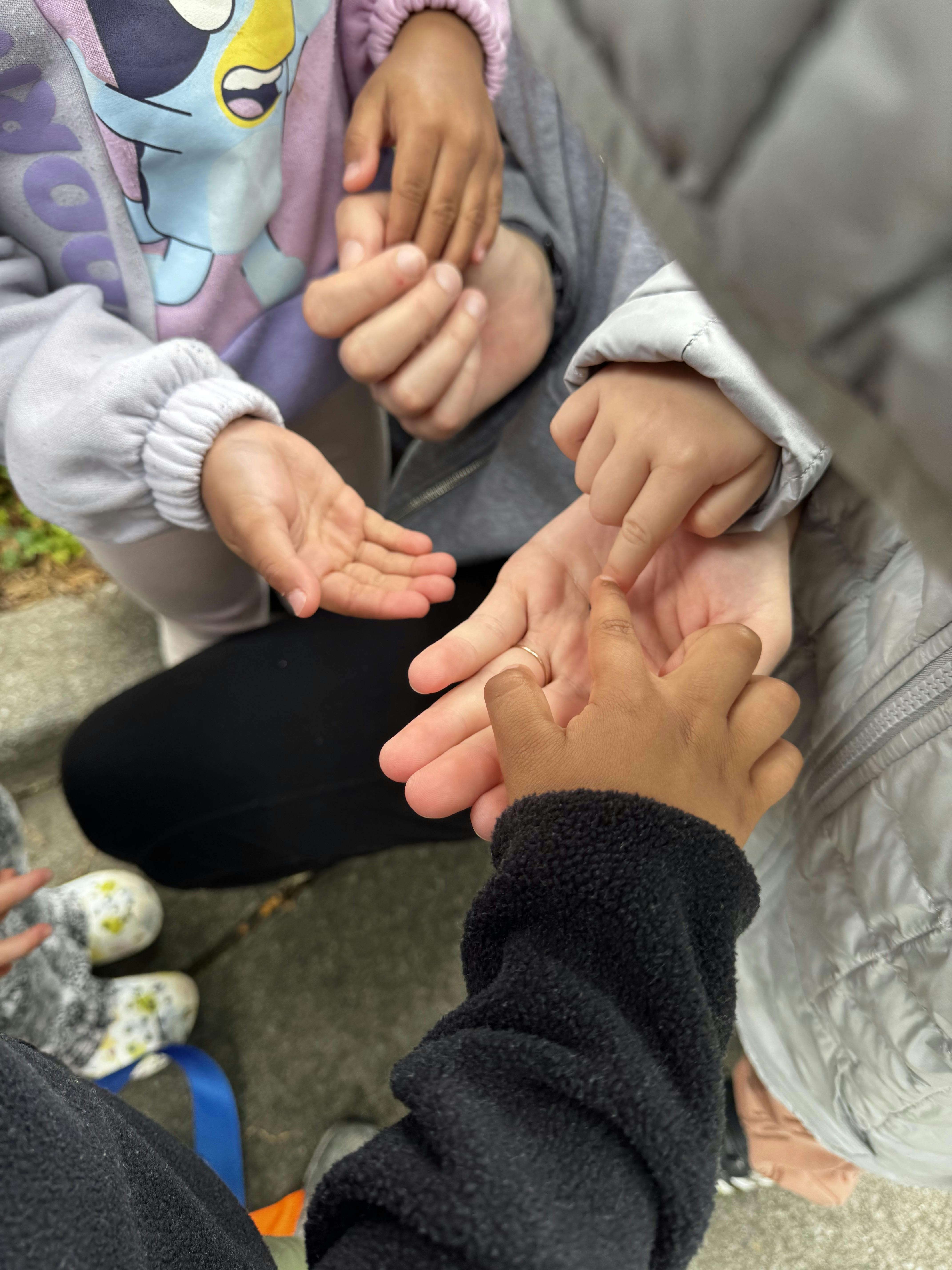 Multiple hands of adults and children stacked together