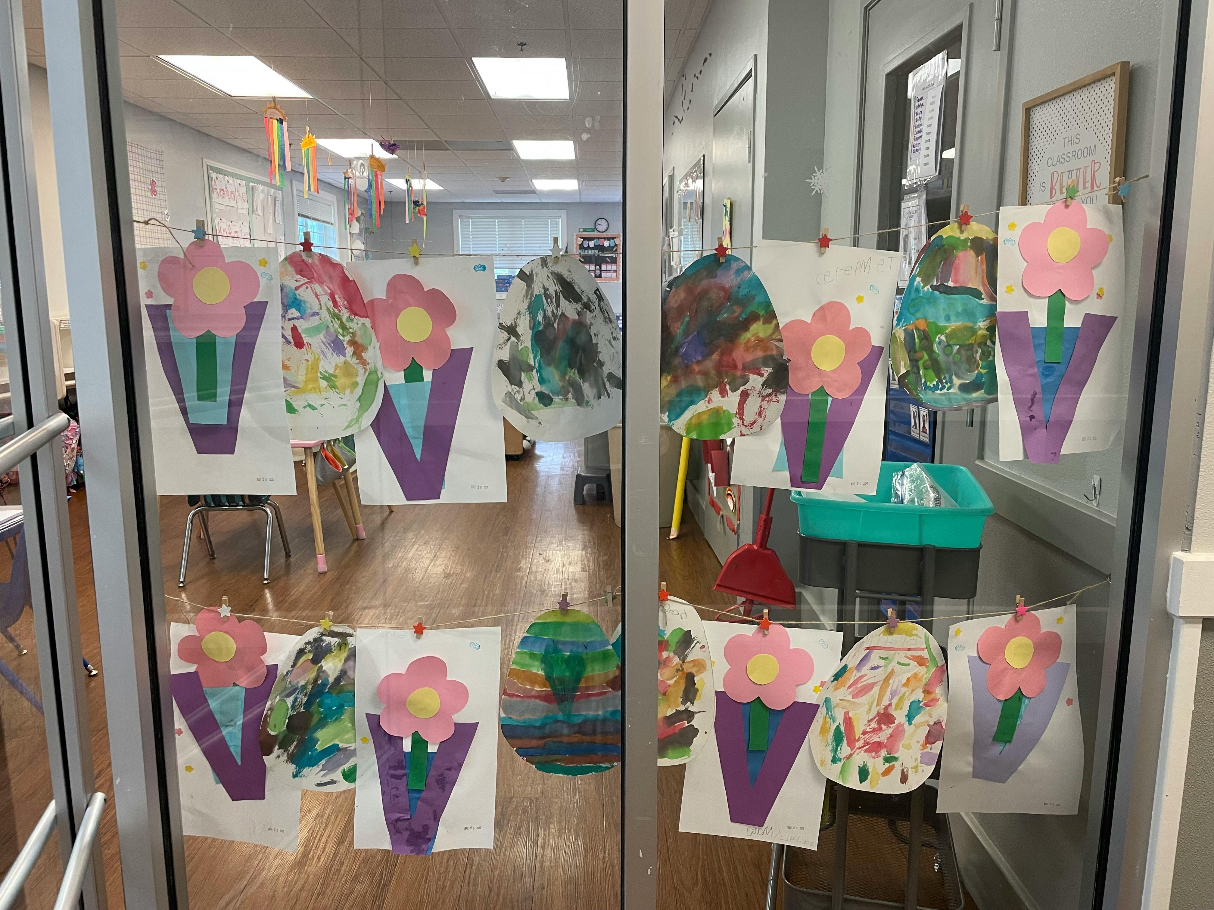 Children's artwork displayed on a glass door