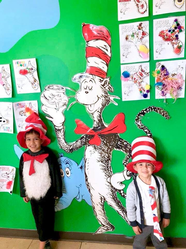 Two children in costumes with a Cat in the Hat cutout