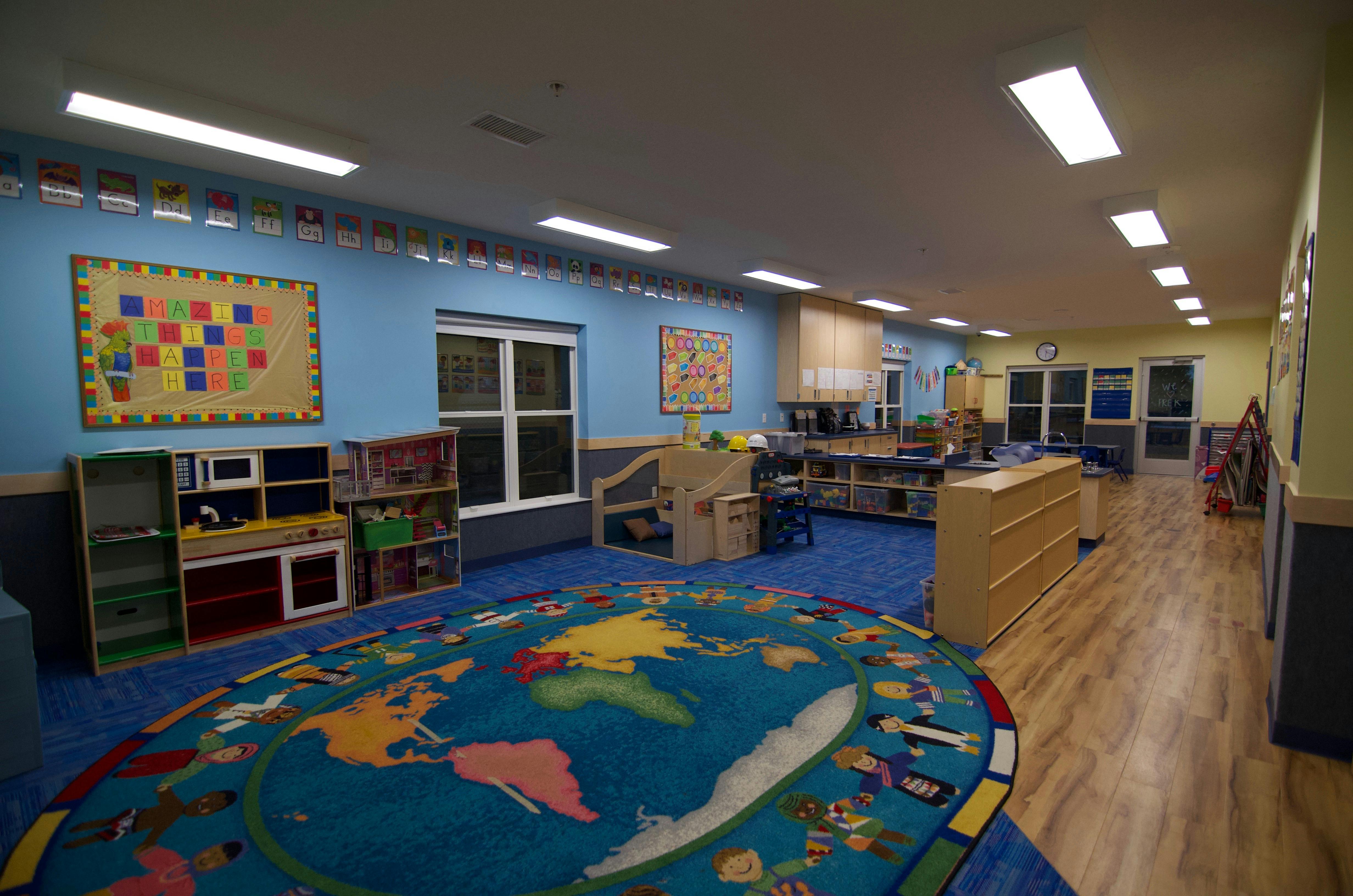 Empty classroom with a world map rug and colorful rug