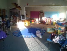 Playroom with toys and a blue rug