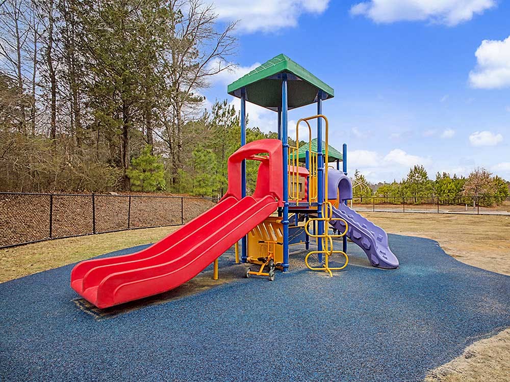 Colorful playground with multiple slides on a blue rubber surface