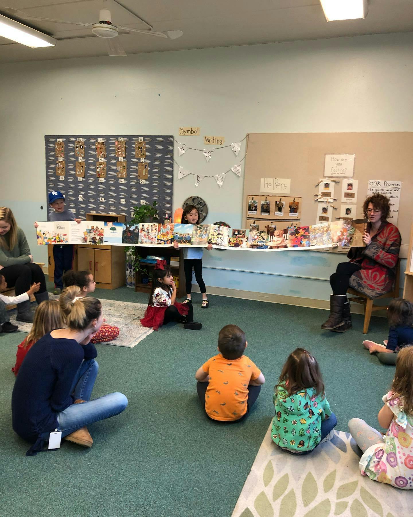 Adults and children sitting on the floor in a classroom