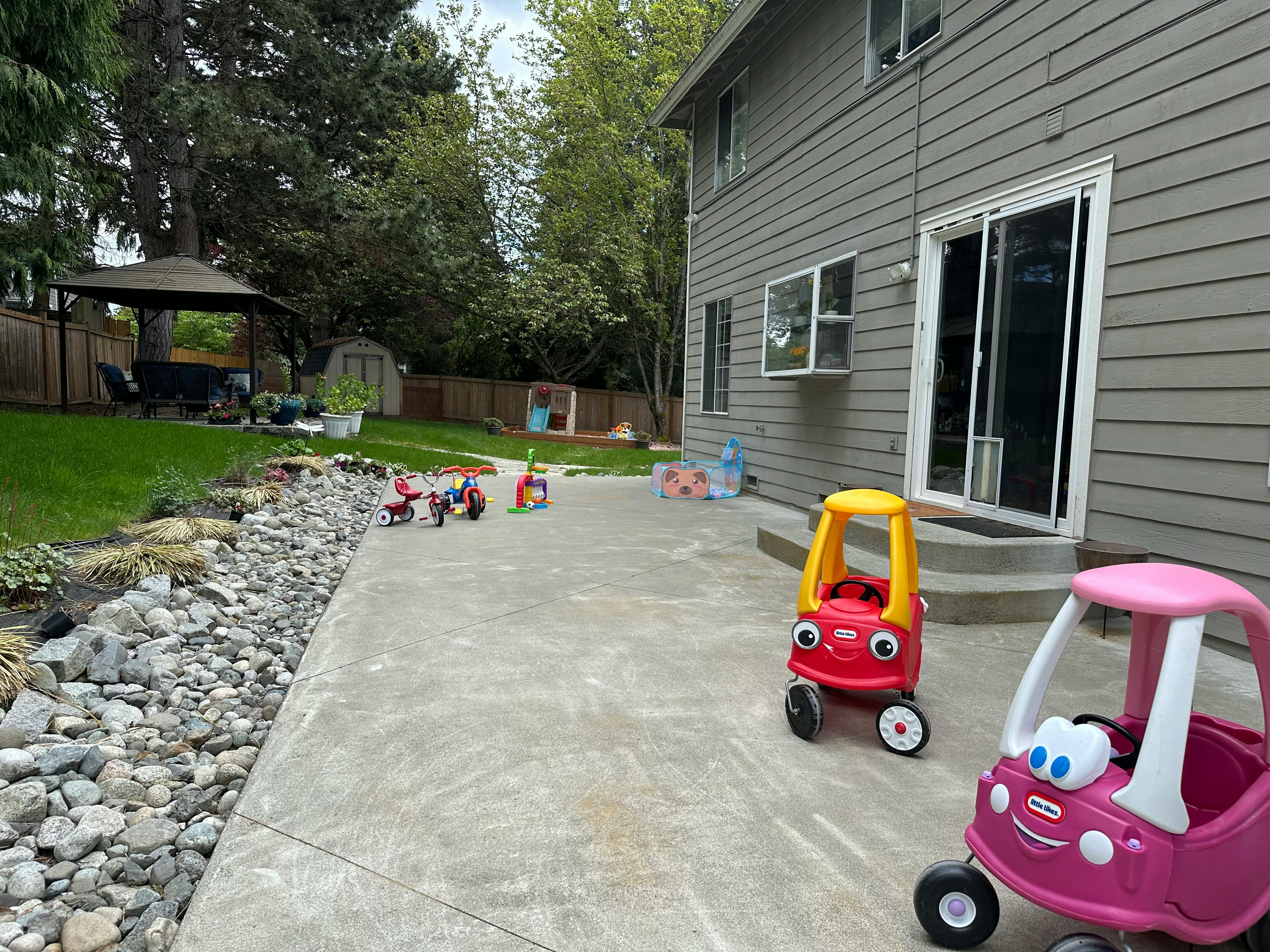 Two toy cars on a patio next to a house