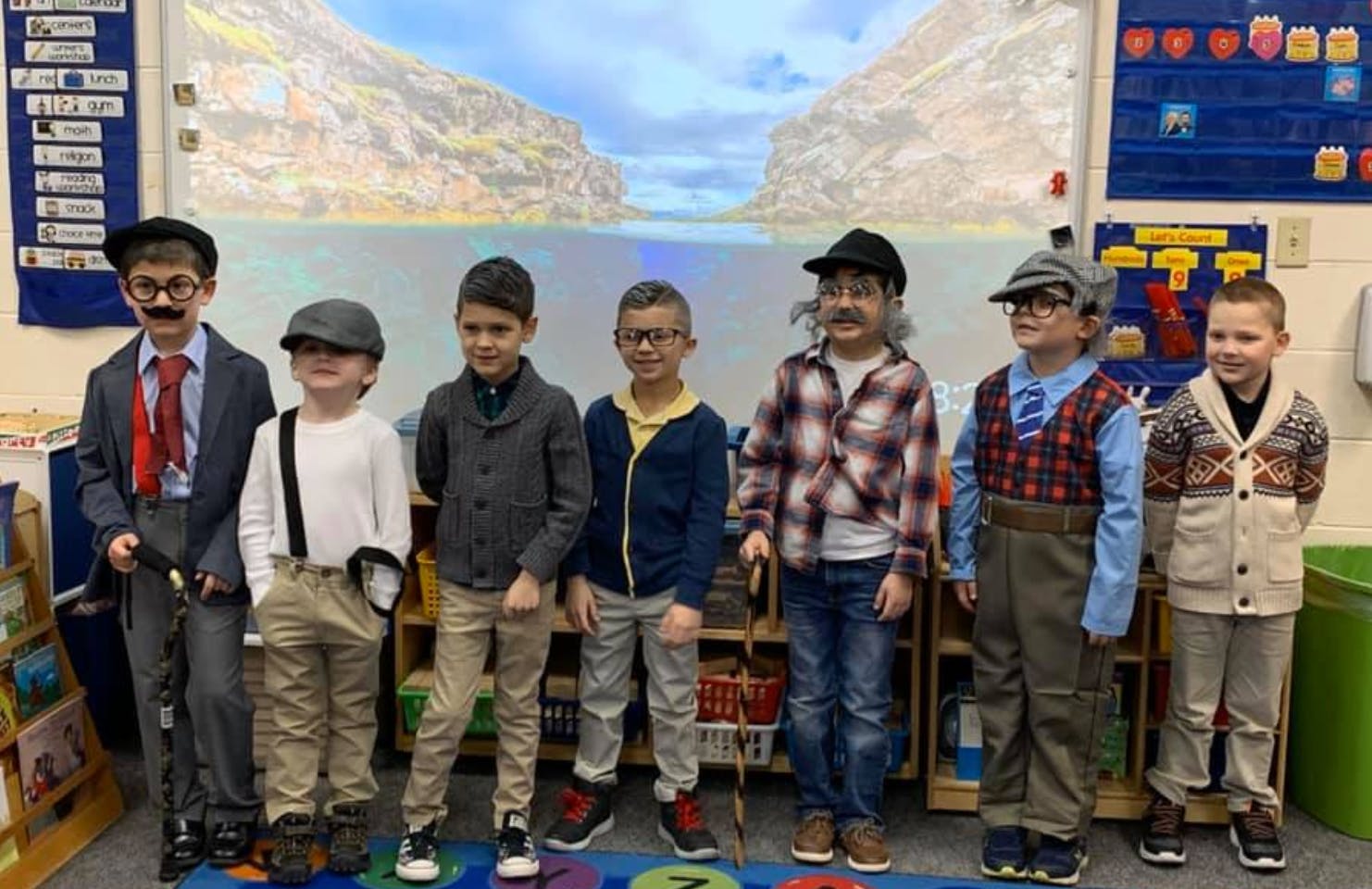 Seven children in a classroom dressed in costumes