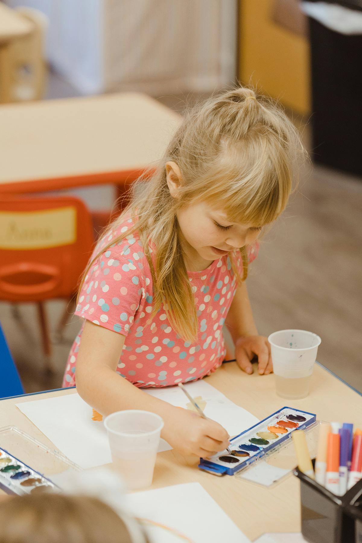 Child painting with watercolors at a table
