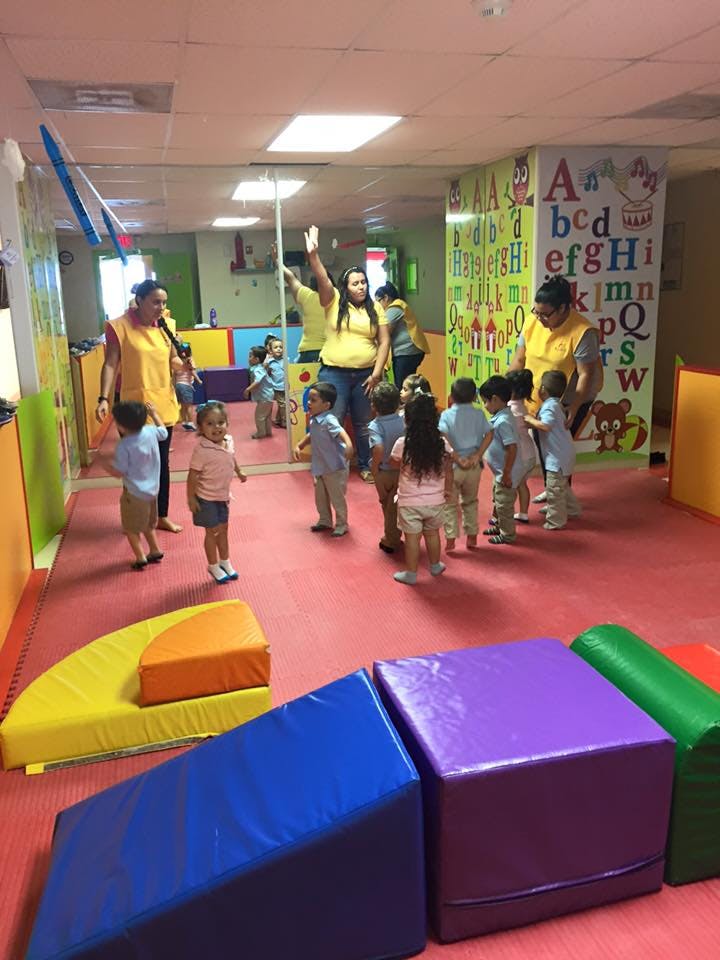 Adults and children in a room with soft play equipment