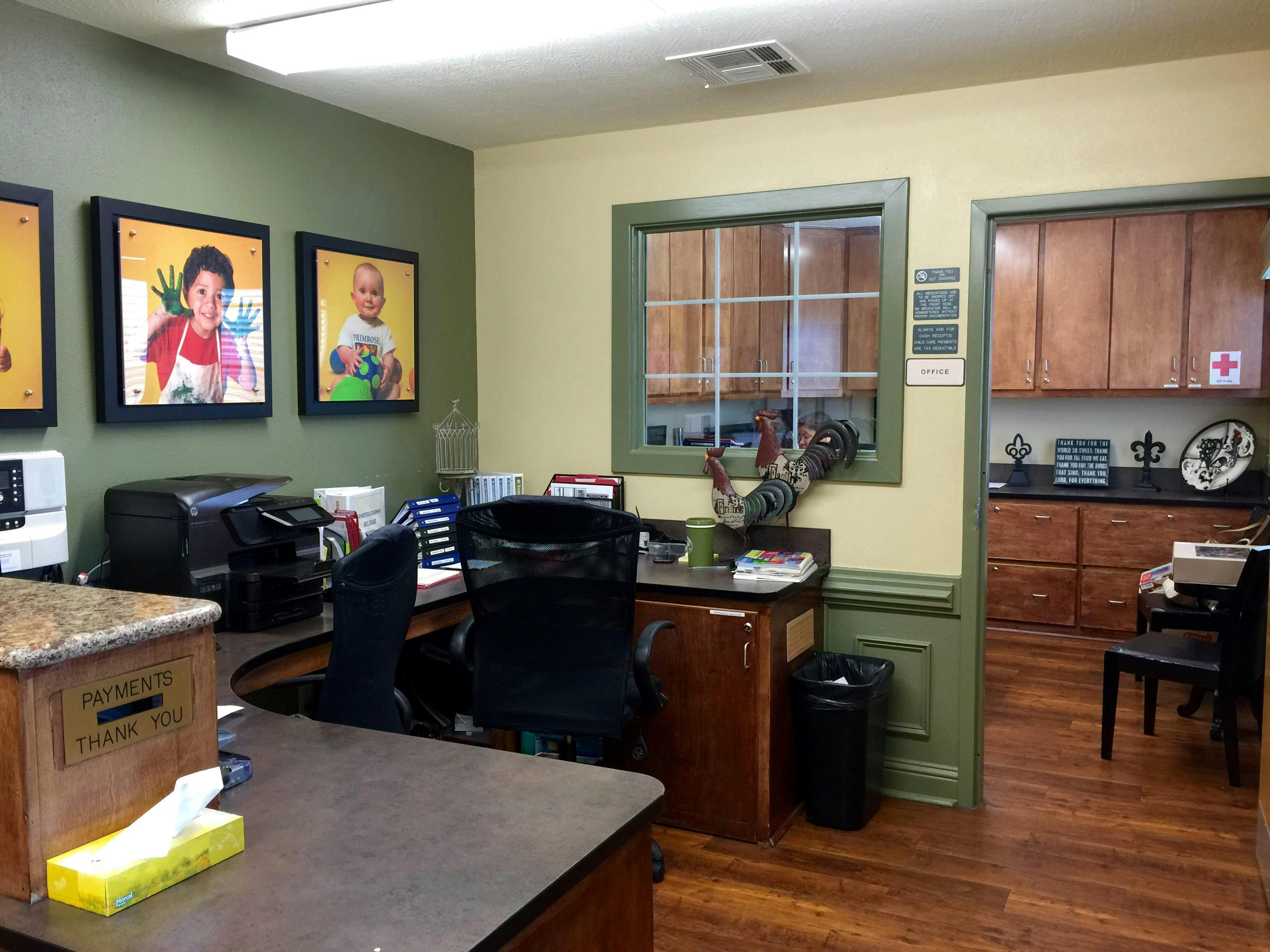 Office space with a desk, chair, and framed pictures on the wall