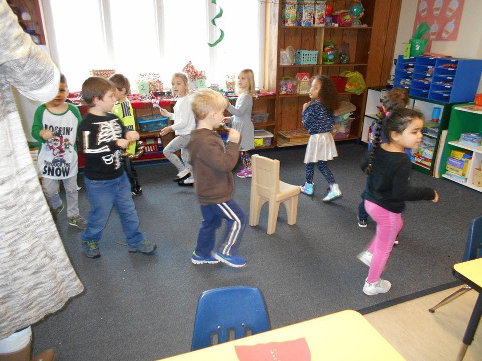 Group of children dancing in a classroom