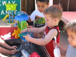 Child playing with water table toy