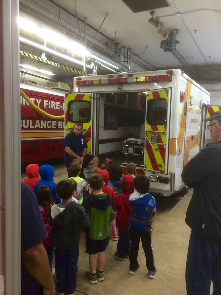 Person showing children the inside of an ambulance