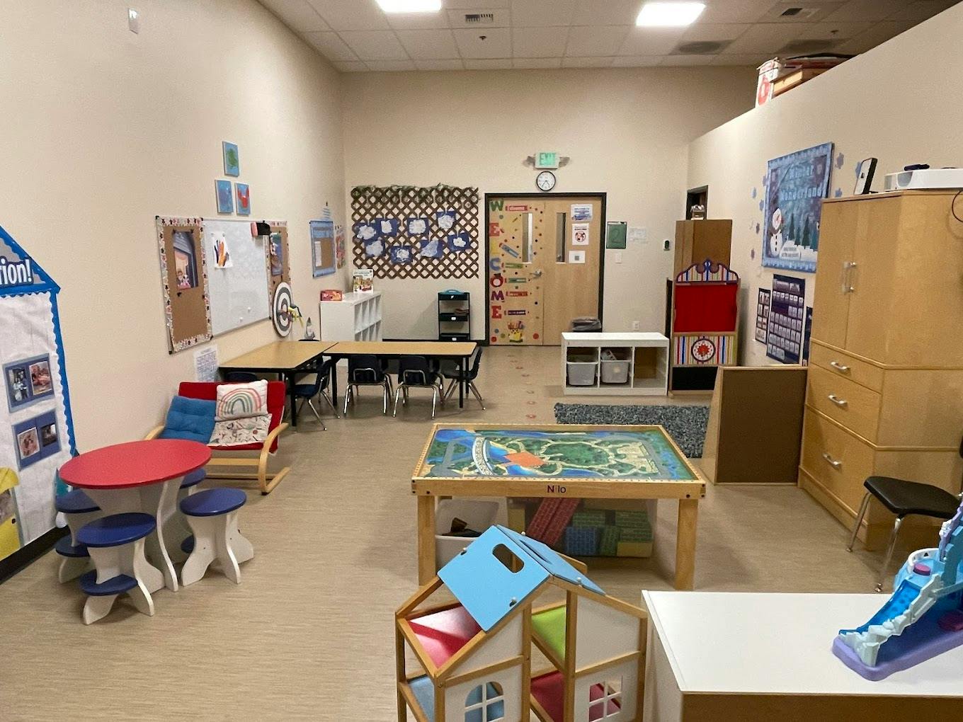 Empty colorful children's play area with tables, chairs, and toys