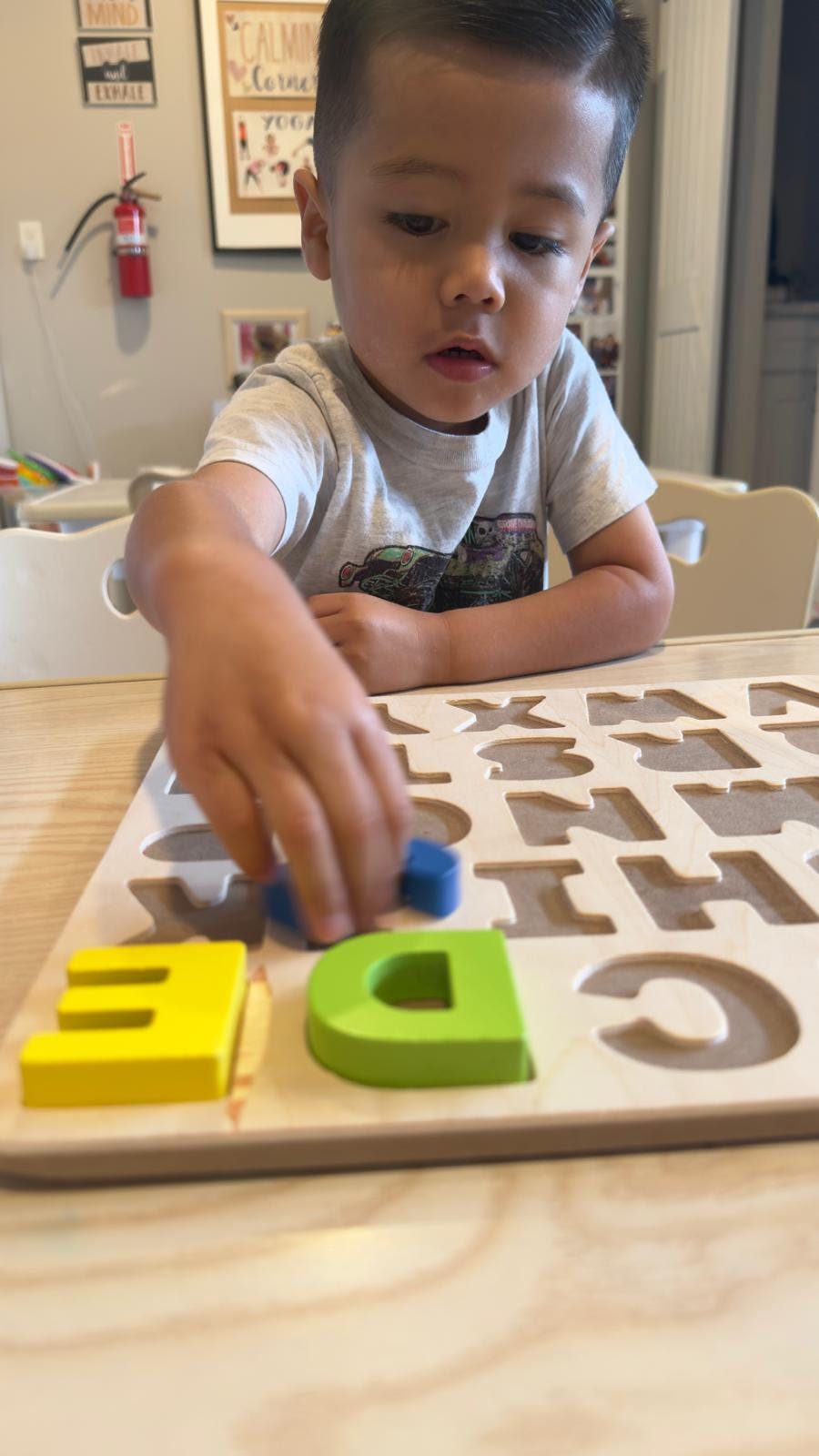 Child playing with a wooden alphabet puzzle