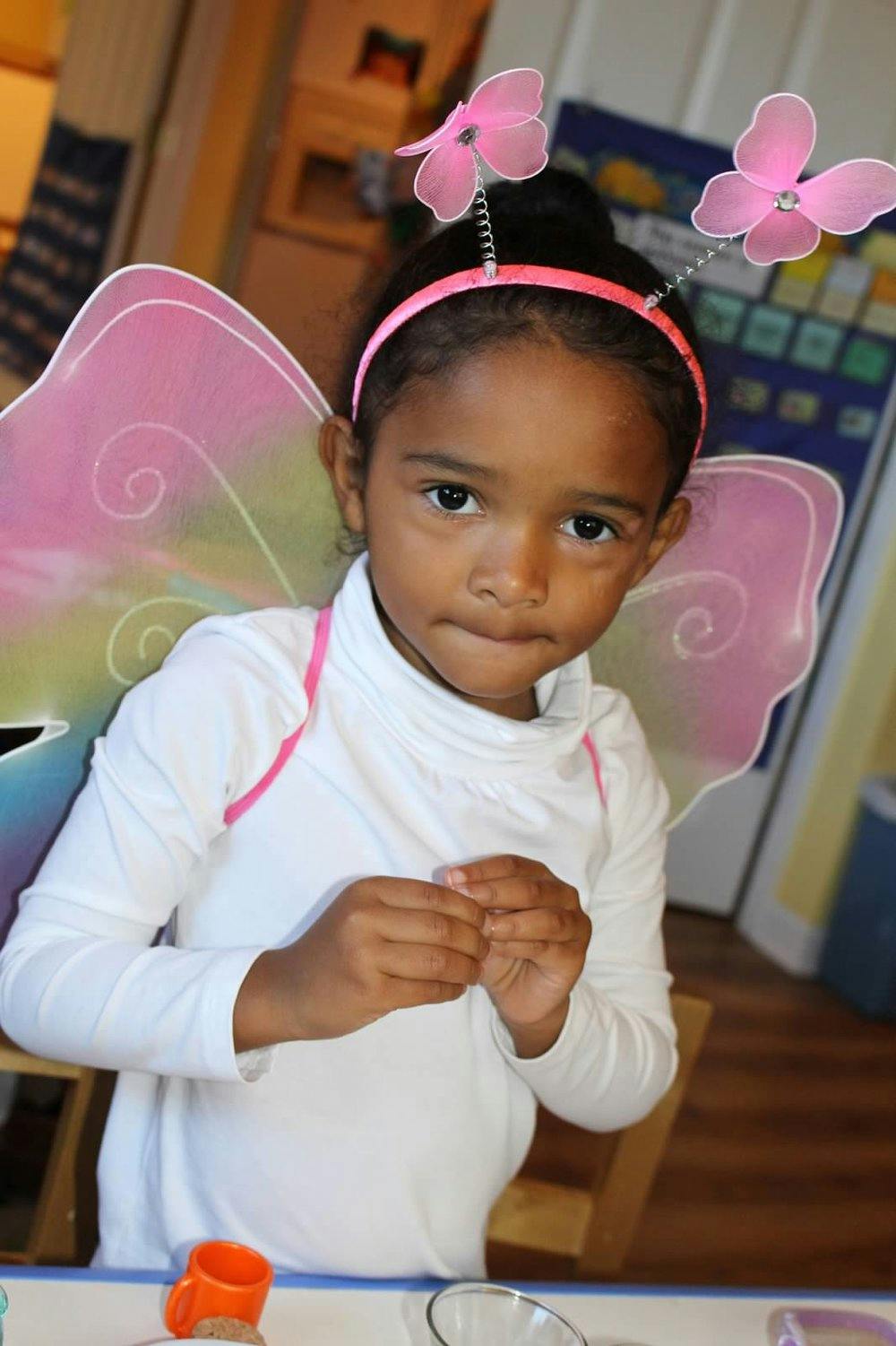 Child wearing a butterfly headband and wings