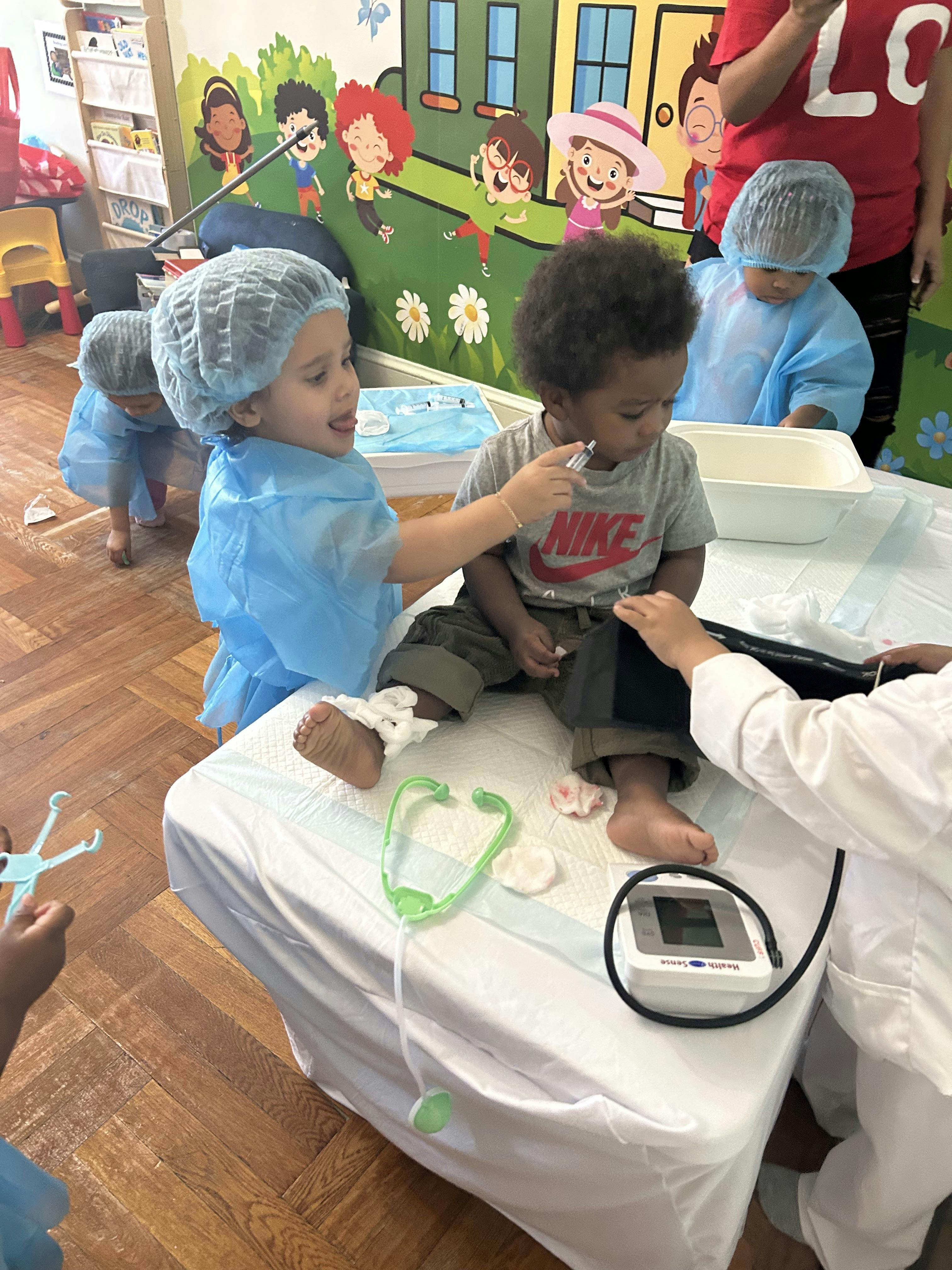 Children dressed as medical staff playing with a toy medical kit