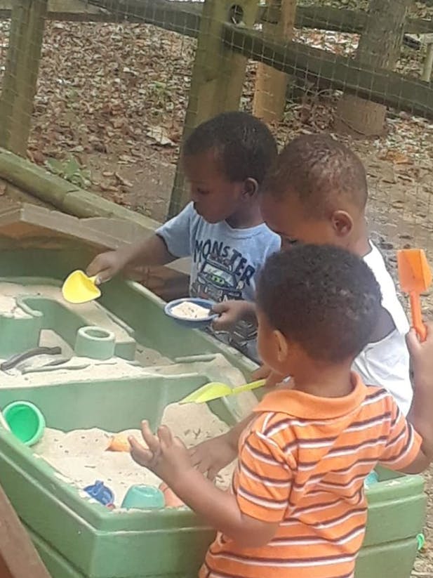Three children playing in a sandbox