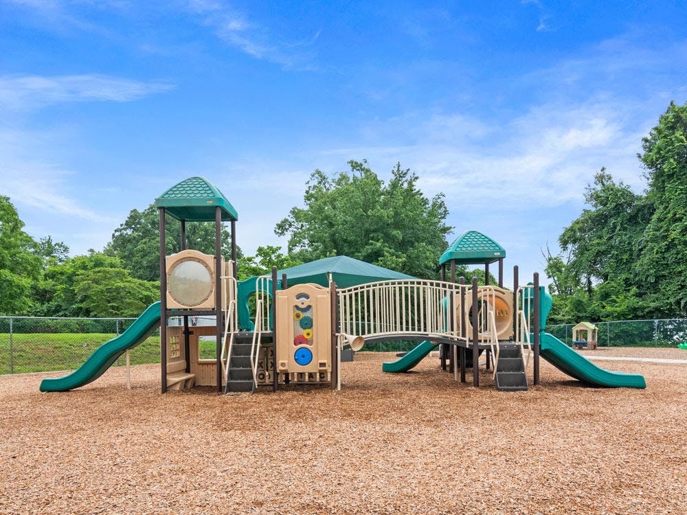 A children's playground with green and tan equipment