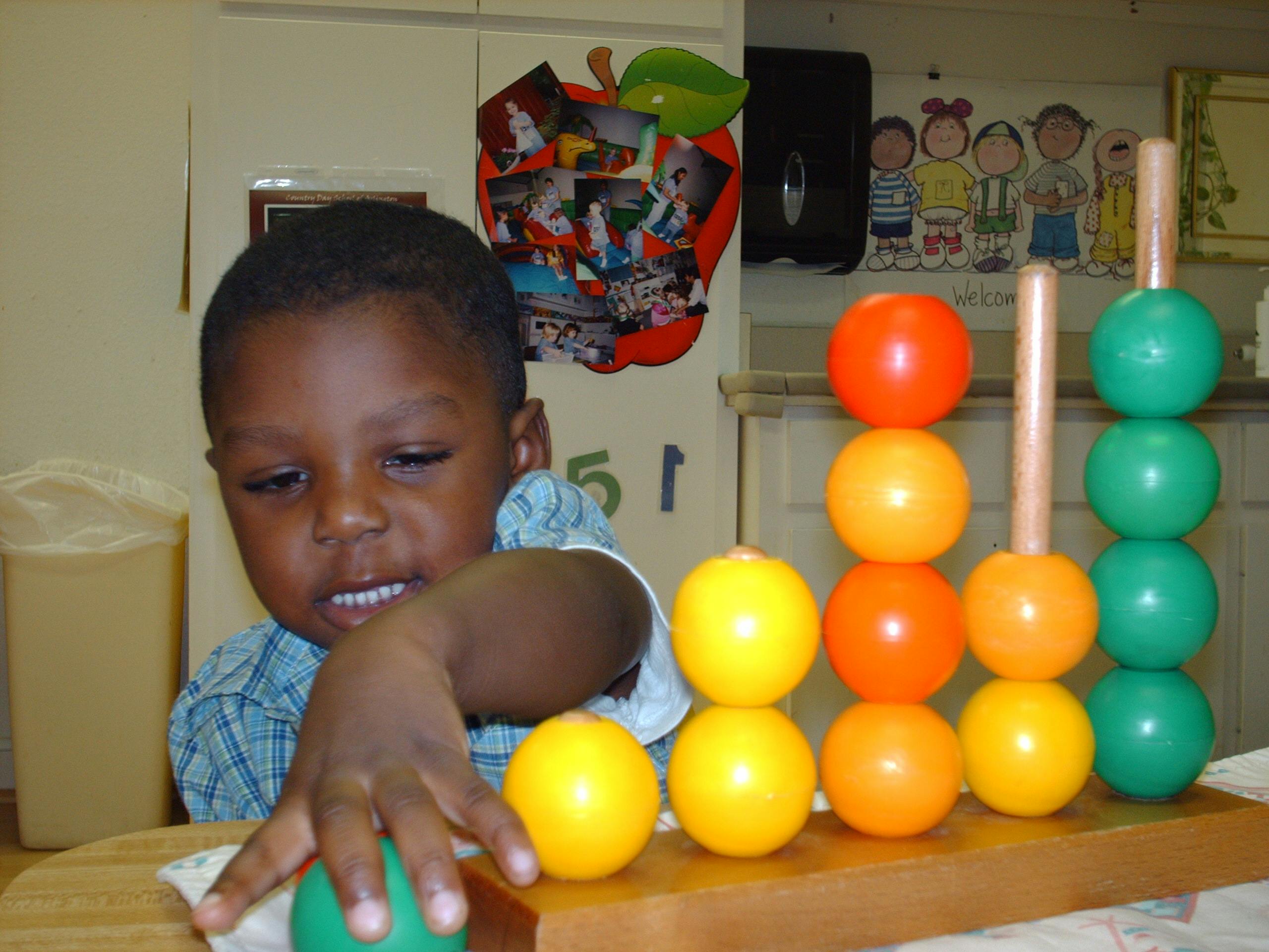 Child playing with a colorful abacus toy